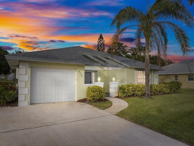 ranch-style home with a garage and a yard