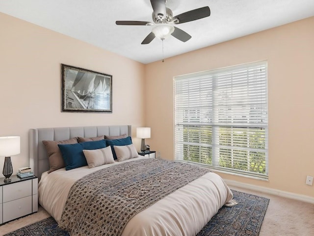 bedroom featuring ceiling fan, carpet floors, and multiple windows