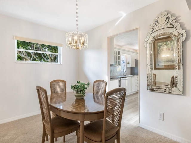 carpeted dining space with a notable chandelier and sink