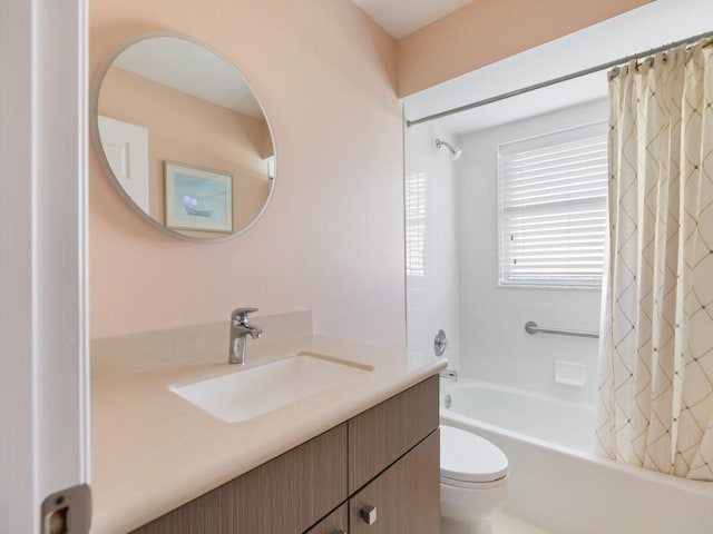 full bathroom featuring shower / tub combo with curtain, vanity, and toilet