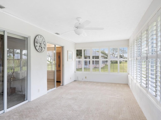 unfurnished sunroom featuring ceiling fan