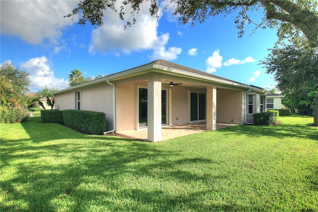 back of house with ceiling fan, a lawn, and a patio area