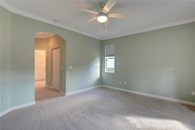 empty room featuring light carpet, crown molding, and ceiling fan