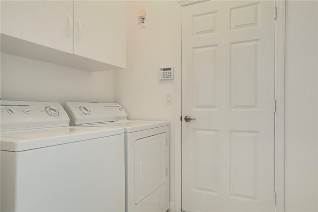 washroom featuring cabinets and washing machine and clothes dryer