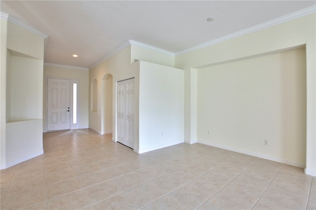 spare room featuring light tile patterned floors and crown molding