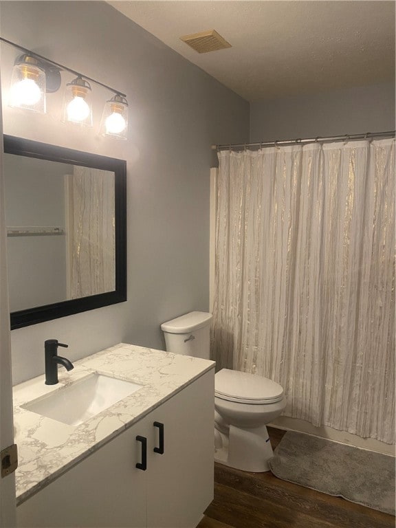 bathroom with toilet, a shower with curtain, vanity, and hardwood / wood-style flooring