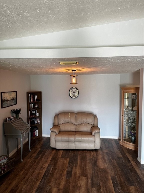 living room featuring dark wood-type flooring, a textured ceiling, and lofted ceiling