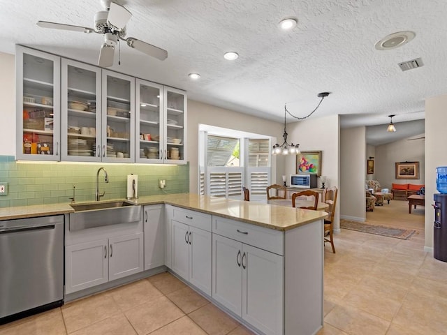 kitchen featuring tasteful backsplash, visible vents, a peninsula, stainless steel appliances, and a sink