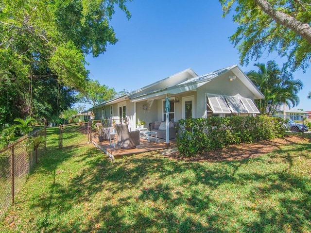 rear view of house featuring stucco siding, a lawn, a fenced backyard, an outdoor hangout area, and a patio area