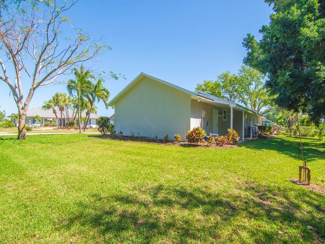 view of side of property featuring a yard and stucco siding