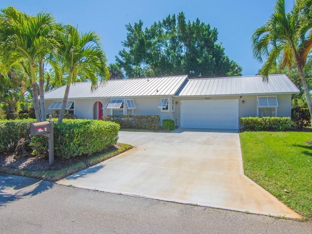 ranch-style house with a front lawn, an attached garage, driveway, and stucco siding