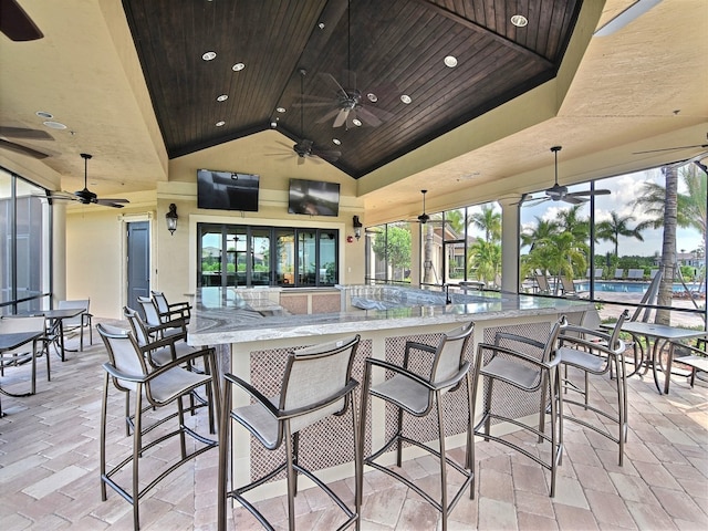 view of patio / terrace featuring a community pool, ceiling fan, and a bar