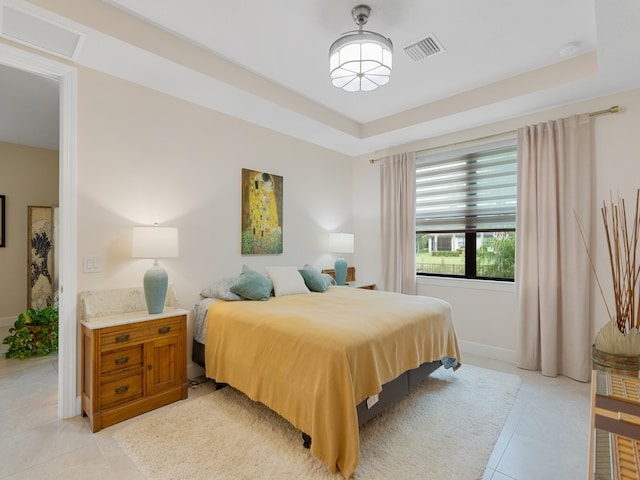 tiled bedroom featuring a raised ceiling