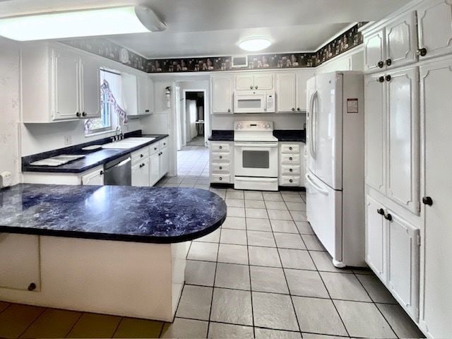 kitchen featuring light tile patterned flooring, sink, white cabinets, and white appliances