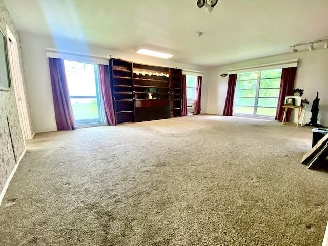 unfurnished living room featuring carpet floors