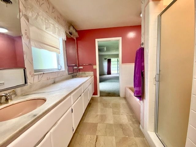 bathroom with shower with separate bathtub, plenty of natural light, and vanity