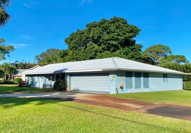 single story home featuring a front lawn and a garage