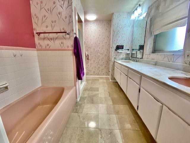 bathroom with vanity and a washtub