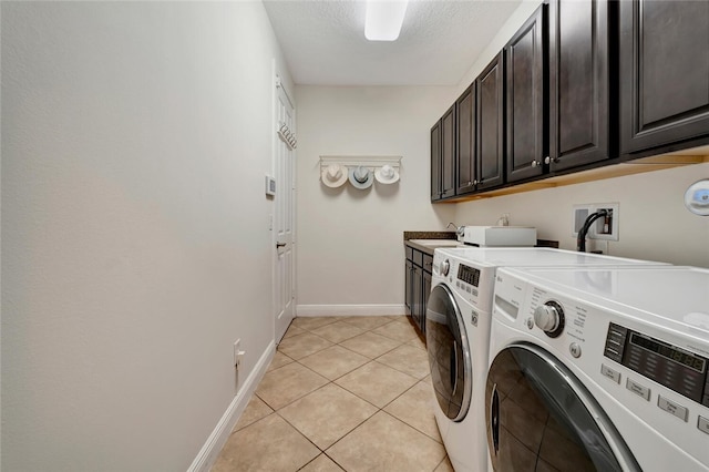 laundry area with cabinets, light tile patterned floors, a textured ceiling, and separate washer and dryer