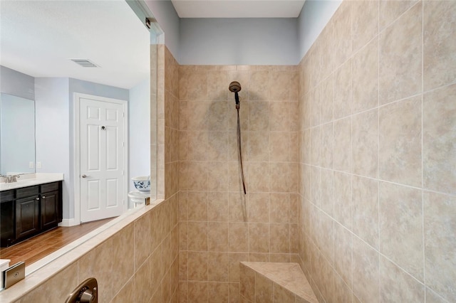 bathroom featuring a tile shower and vanity