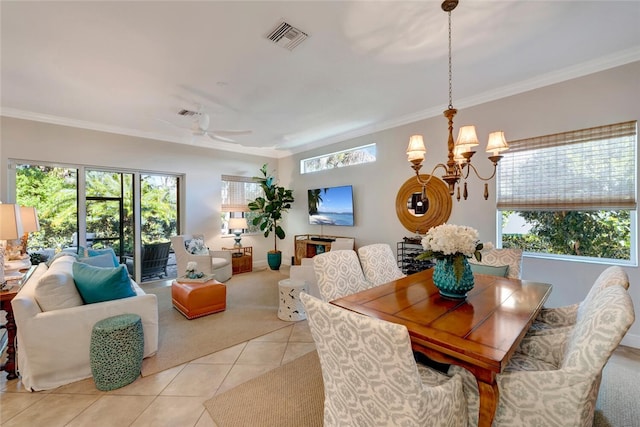 dining area with a wealth of natural light, light tile patterned floors, ceiling fan with notable chandelier, and ornamental molding