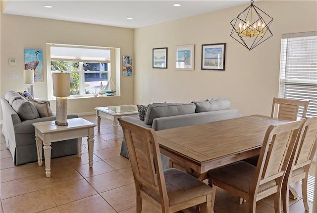 tiled dining room with an inviting chandelier