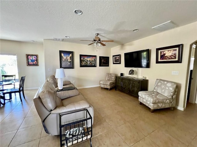 tiled living room featuring a textured ceiling and ceiling fan