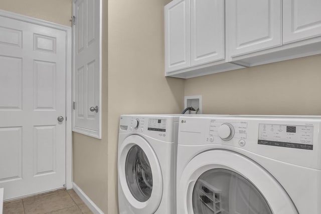 washroom featuring cabinets, independent washer and dryer, and light tile patterned floors