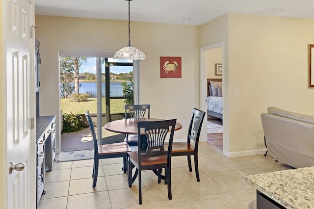 tiled dining room featuring a water view