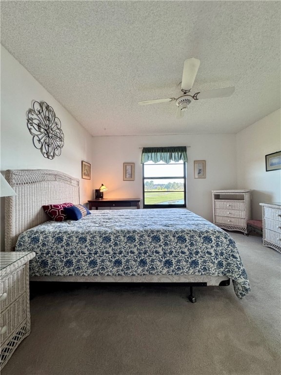 bedroom with ceiling fan, carpet, and a textured ceiling