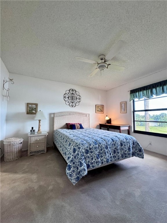 bedroom featuring carpet flooring, ceiling fan, and a textured ceiling