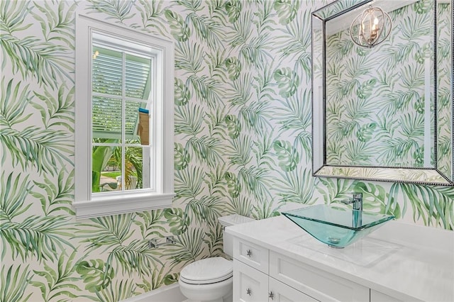 765 Azalea Ln, Vero Beach, FL 32963 - bathroom with wallpapered walls, toilet, vanity, a chandelier, and baseboards
