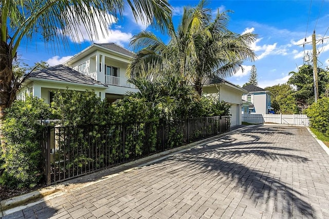 765 Azalea Ln, Vero Beach, FL 32963 - view of side of property with a balcony, a fenced front yard, stucco siding, and a gate