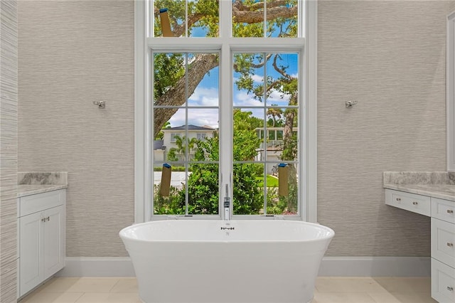 765 Azalea Ln, Vero Beach, FL 32963 - bathroom featuring vanity, baseboards, a soaking tub, and tile patterned floors