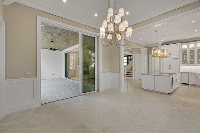 765 Azalea Ln, Vero Beach, FL 32963 - kitchen with a chandelier, paneled fridge, a decorative wall, a wainscoted wall, and white cabinets