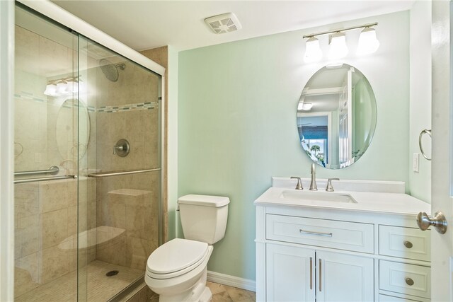 bathroom featuring toilet, vanity, and a shower with door