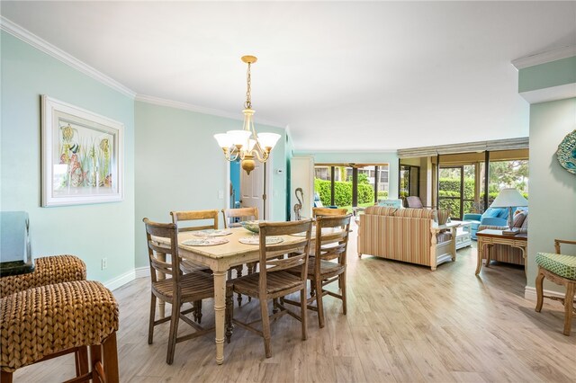 dining space with light wood-type flooring, a chandelier, and crown molding