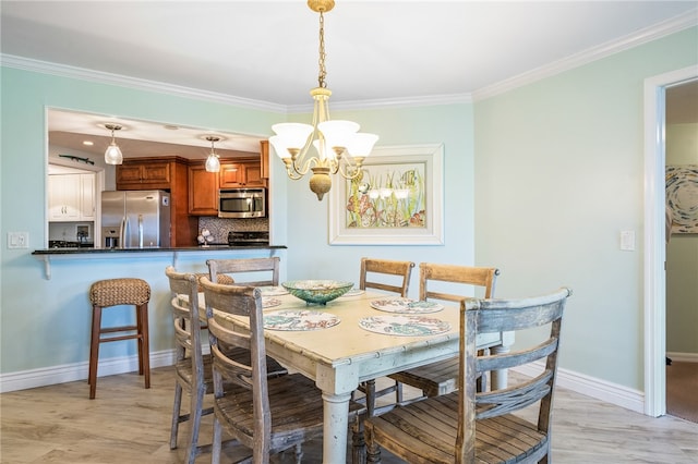 dining space featuring ornamental molding, light hardwood / wood-style floors, and a notable chandelier