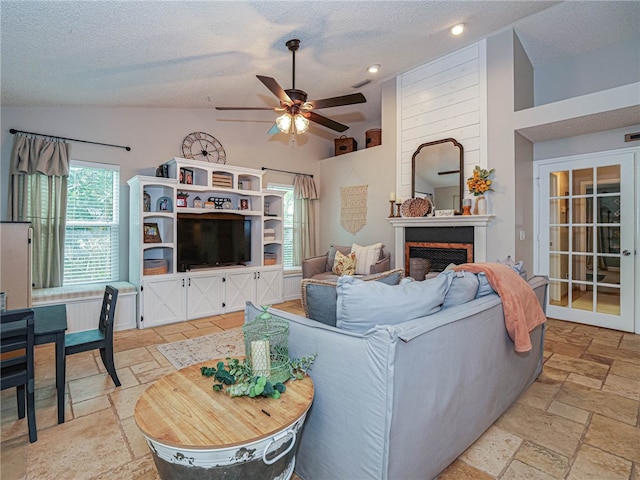 living room featuring a textured ceiling, high vaulted ceiling, and ceiling fan