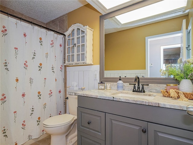 bathroom featuring vanity, a textured ceiling, toilet, and a shower with shower curtain