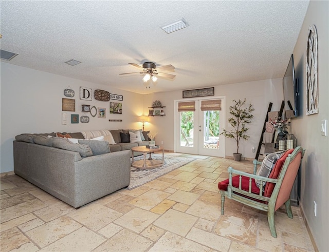 living room with ceiling fan, a textured ceiling, and french doors