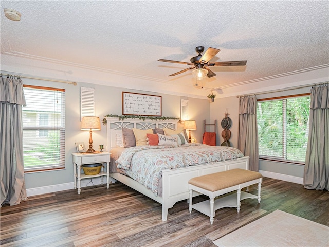 bedroom with dark hardwood / wood-style floors, ceiling fan, crown molding, and a textured ceiling