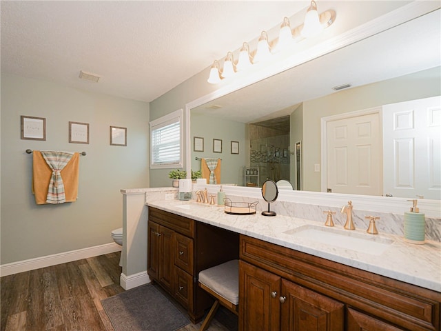 bathroom with vanity, hardwood / wood-style flooring, toilet, and a shower with shower door