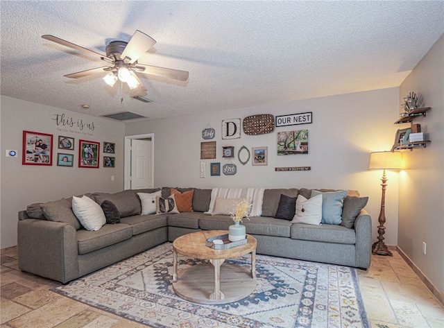 living room featuring a textured ceiling and ceiling fan