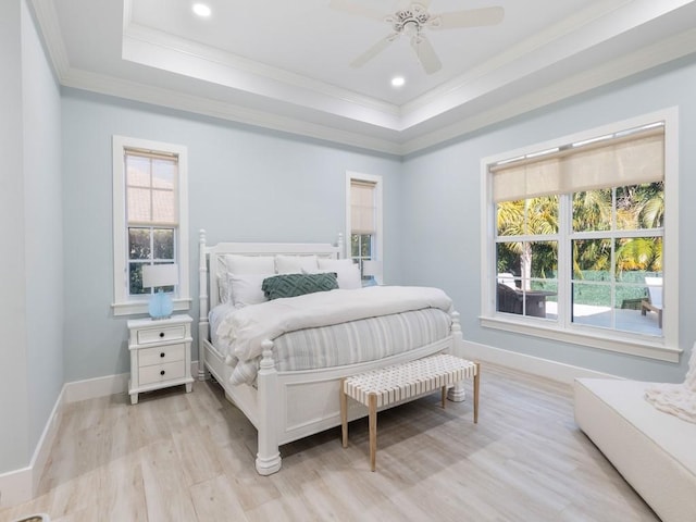 1618 W Sandpointe Pl, Vero Beach, FL 32963 - bedroom with ornamental molding, a tray ceiling, multiple windows, light wood-style floors, and a ceiling fan