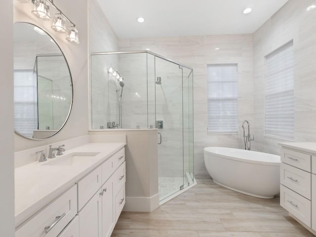 1618 W Sandpointe Pl, Vero Beach, FL 32963 - full bathroom with vanity, a freestanding tub, a stall shower, wood finished floors, and recessed lighting