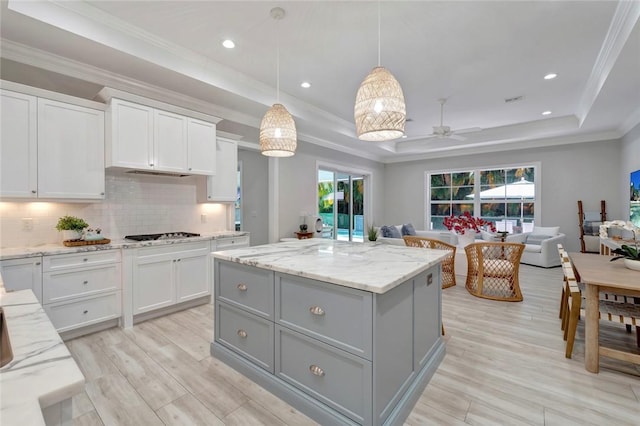 1618 W Sandpointe Pl, Vero Beach, FL 32963 - kitchen with a raised ceiling, gray cabinets, a center island, ceiling fan, and crown molding