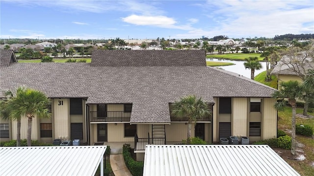 view of front facade with a water view and a shingled roof