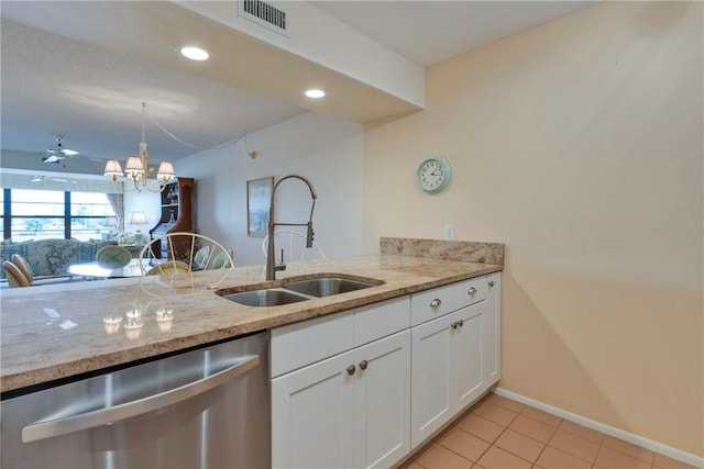 kitchen with light stone counters, visible vents, white cabinetry, a sink, and dishwasher