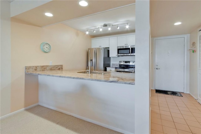 kitchen with recessed lighting, stainless steel appliances, a peninsula, and white cabinets